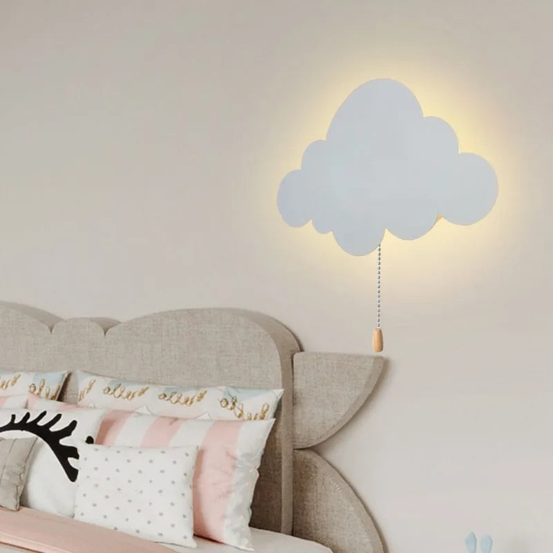 White cloud-shaped wall lamp glowing softly above a child's bed