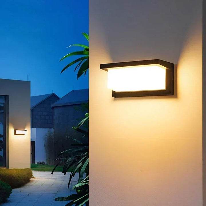 Outdoor LED wall light with motion sensor mounted on exterior brick wall