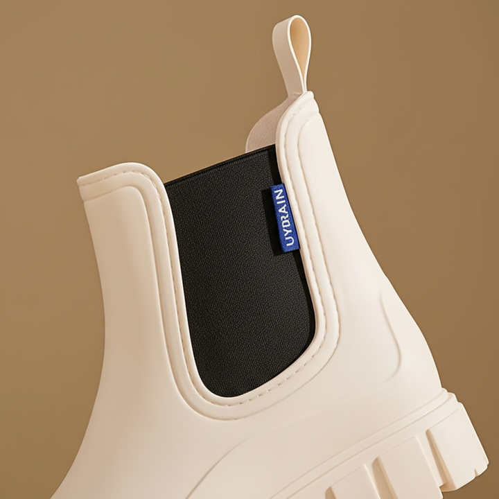 Close-up detail of the elastic side gore and pull tab on beige rain boots Doris