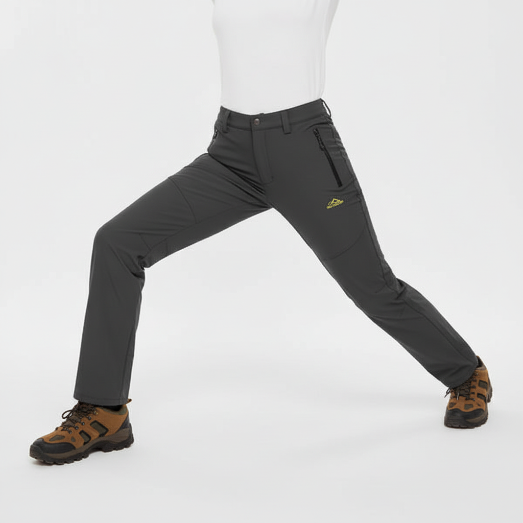 Woman wearing dark grey waterproof lined hiking trousers in a studio pose