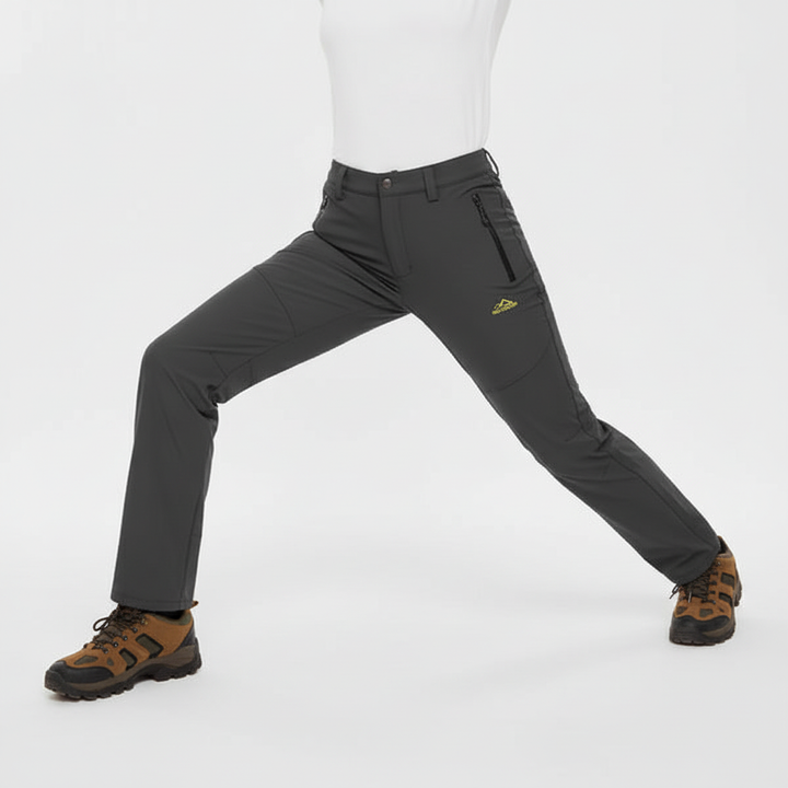 Woman wearing dark grey waterproof lined hiking trousers in a studio pose