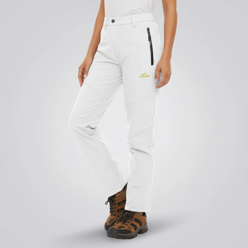 Woman wearing white waterproof lined outdoor trousers with zipped pockets