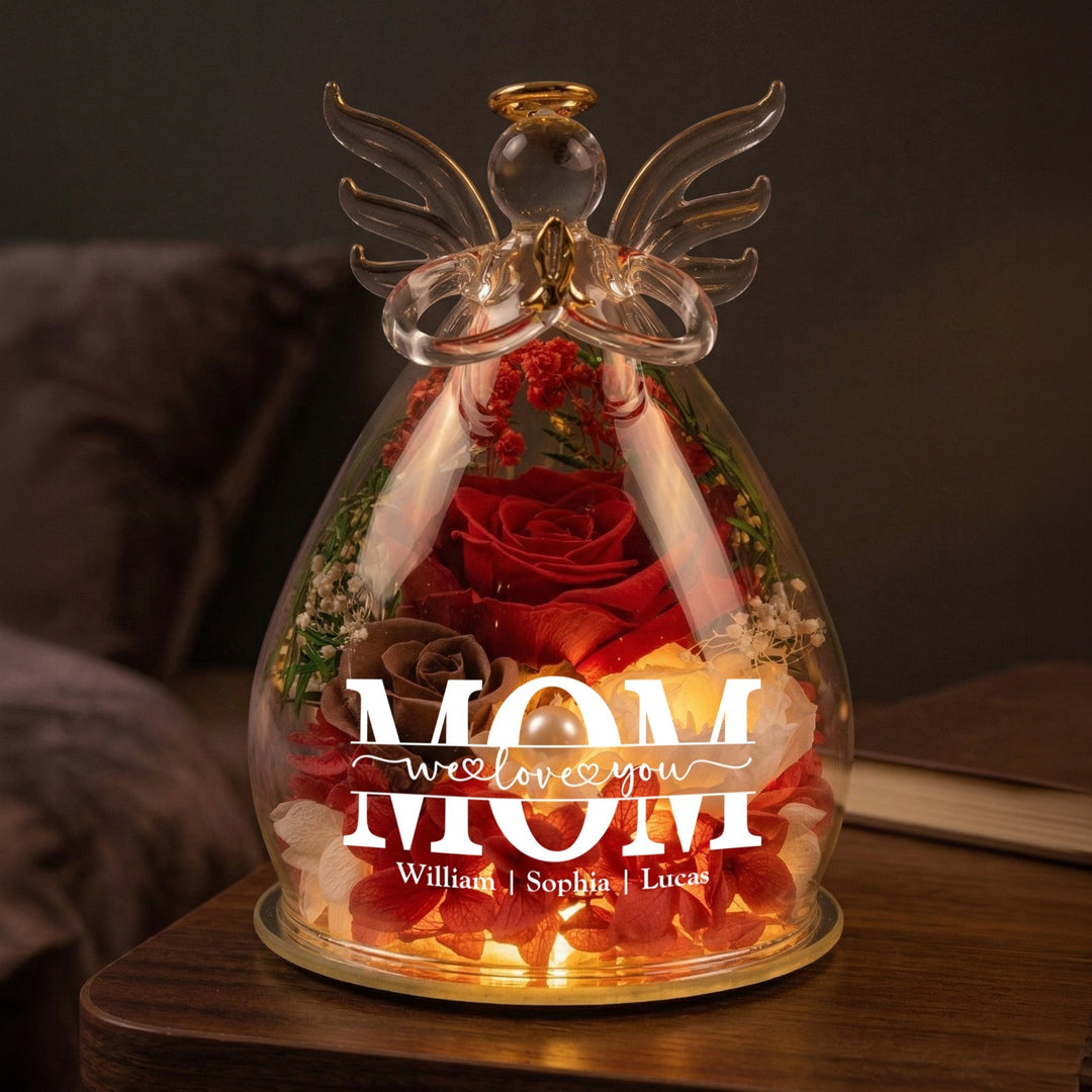 Illuminated glass angel figurine with a red preserved rose and custom text for mom on a wooden surface