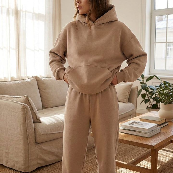 Woman wearing a khaki oversized hoodie and sweatpants tracksuit set indoors