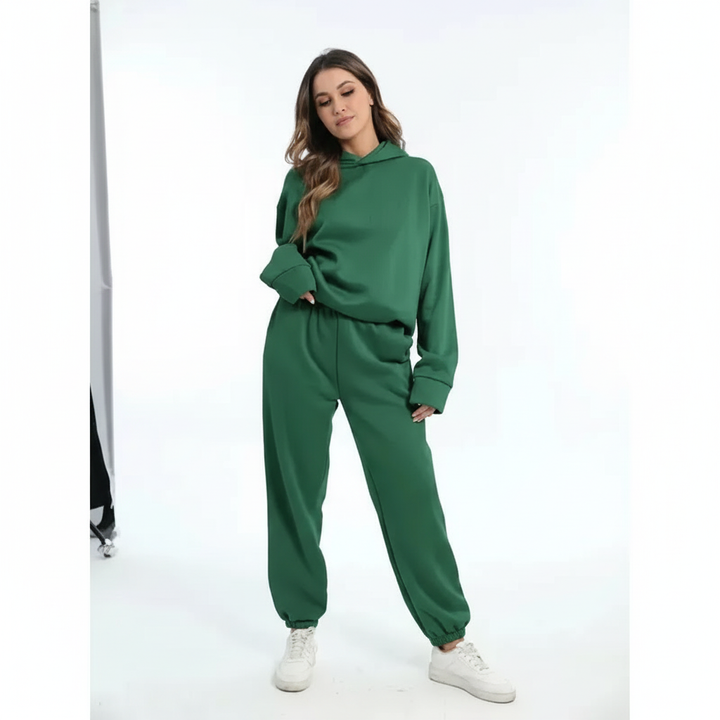 Full-body view of a woman wearing a green fleece lounge set against a white background