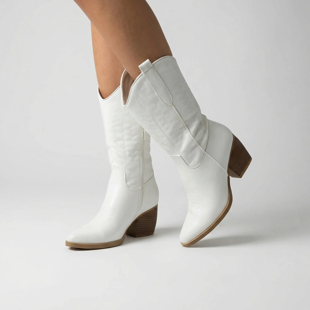 Close-up view of white western boots with pointed toe and side zipper