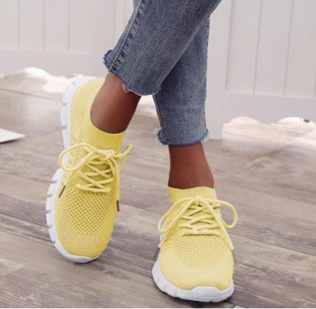 Women's yellow lightweight knit lace-up sneakers worn with jeans