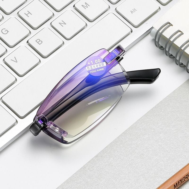 Folded reading glasses resting on a computer keyboard