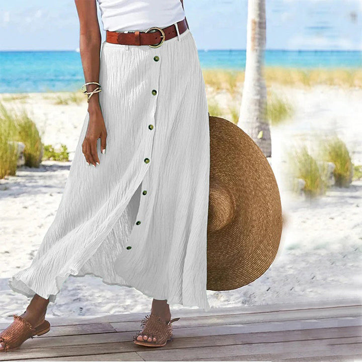 Woman wearing white A-line button midi skirt with beach background