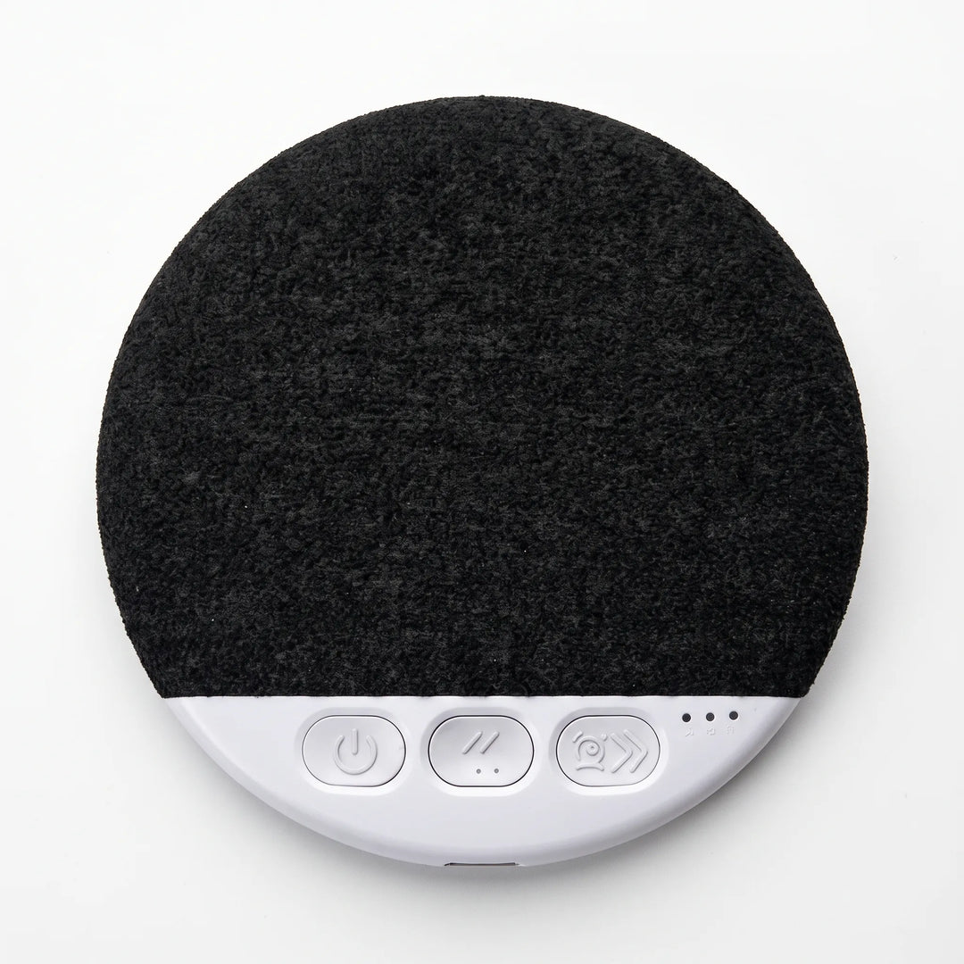 Top-down view of the round black under pillow speaker with tactile controls