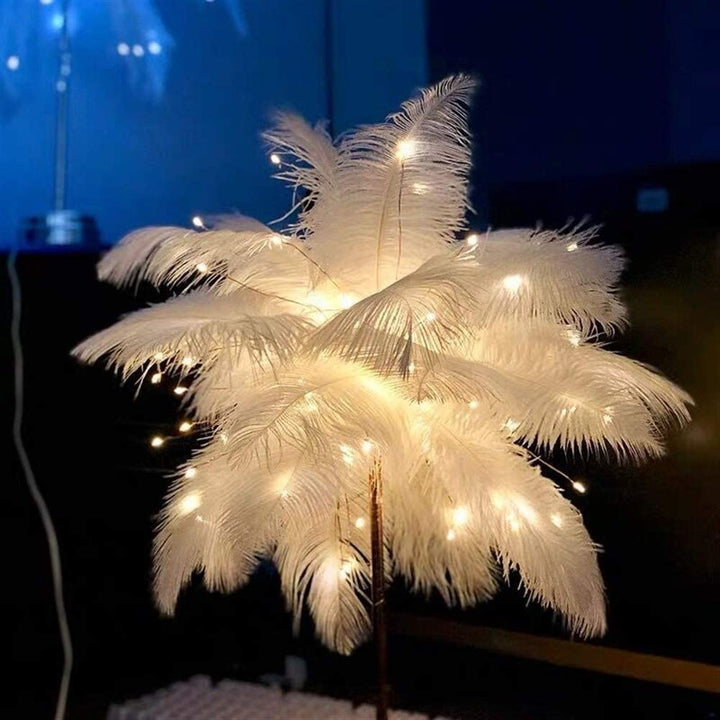 Stylish ambient table lamp featuring soft white feathers and a metallic rose-gold stand