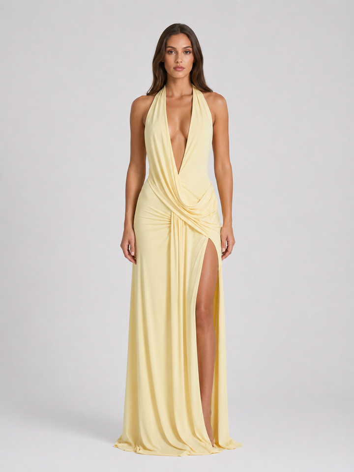 Front view of a model wearing the yellow halterneck maxi dress with a deep V-neck and high side split