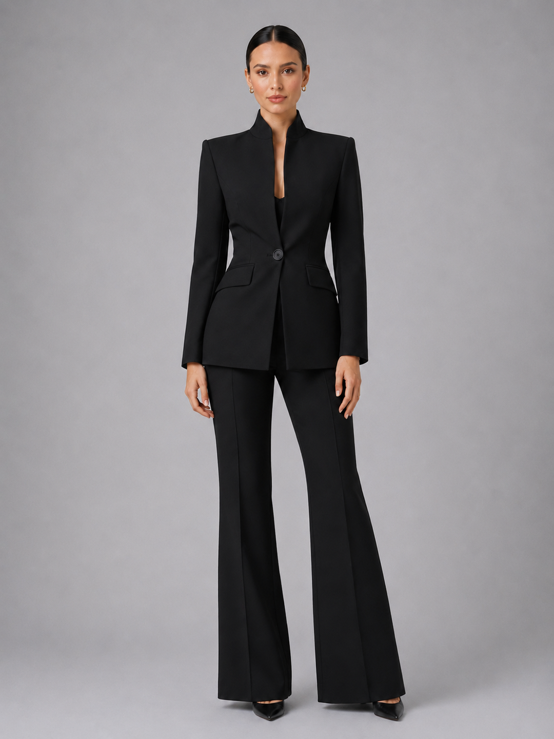 Front view of a model wearing a black women's collarless blazer and palazzo trousers suit set