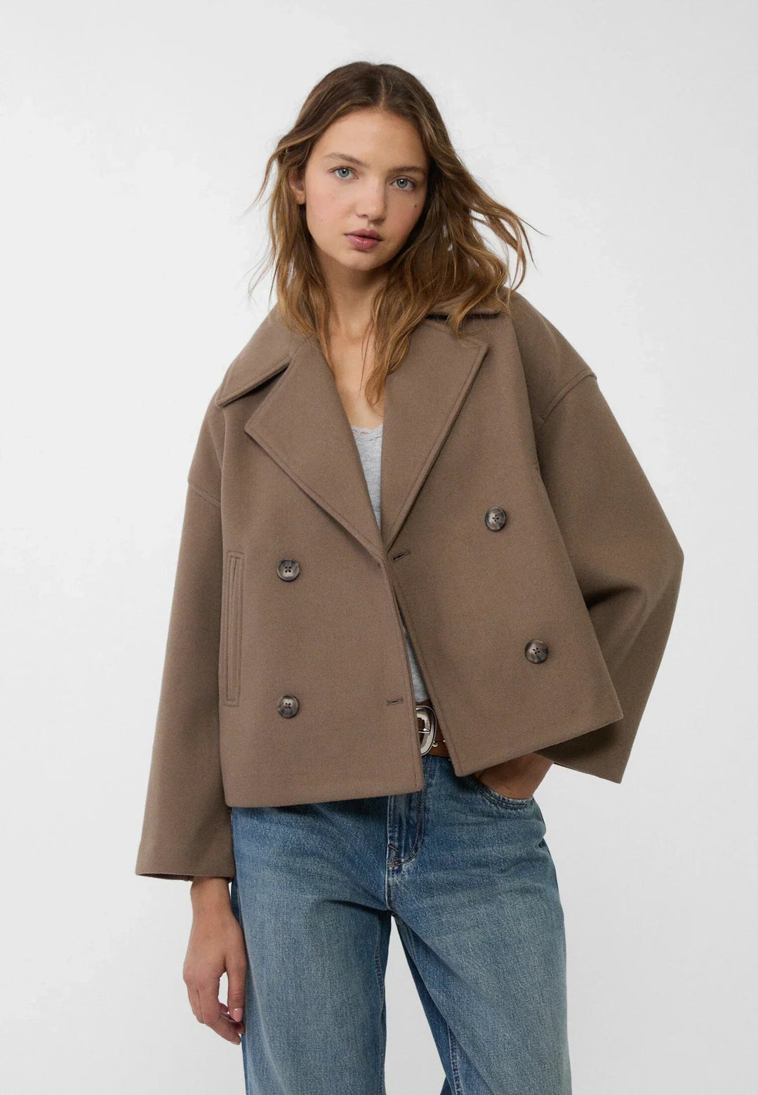 Model wearing a brown cropped winter jacket with double-breasted buttons