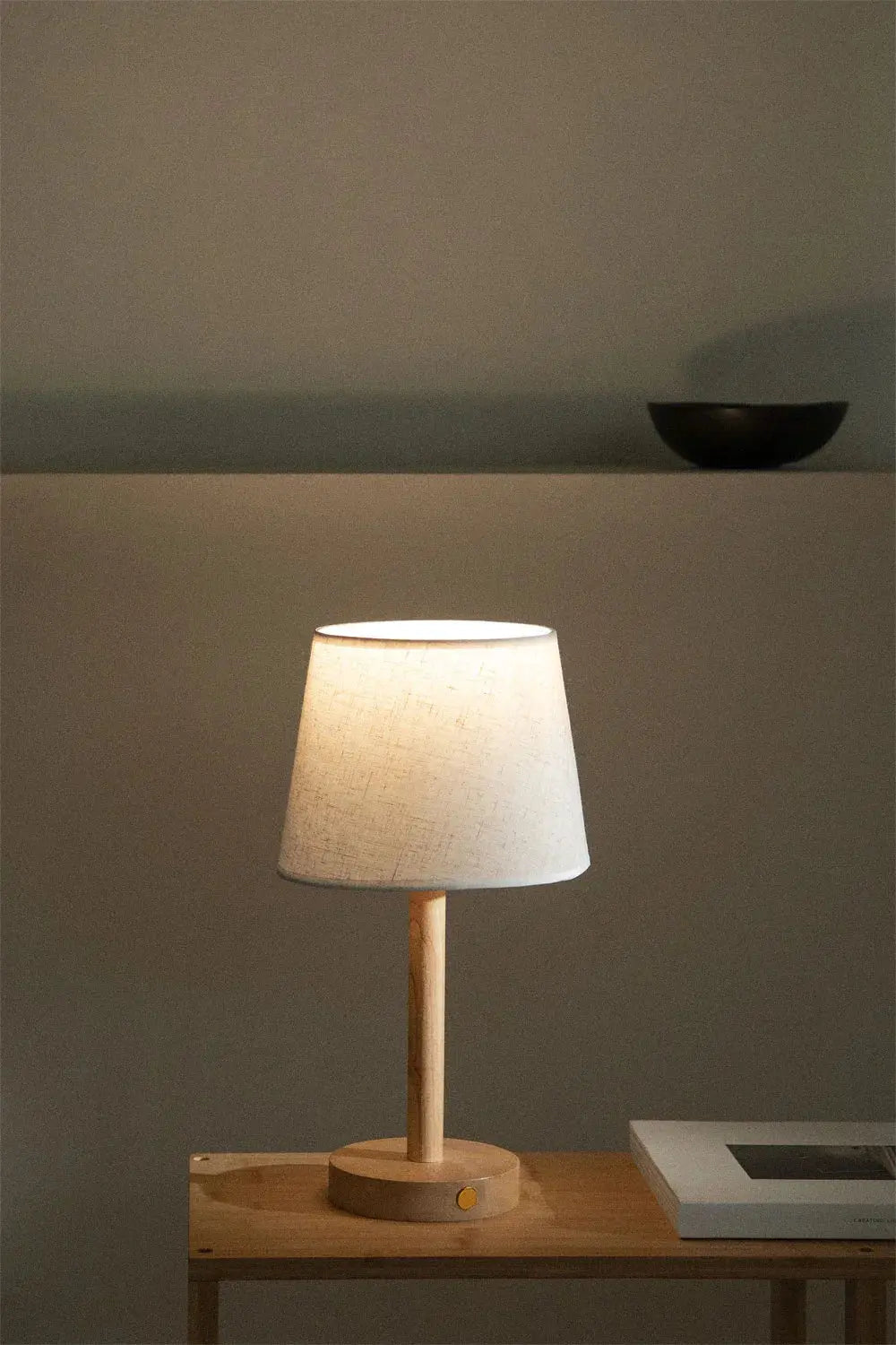 Cordless wooden LED night lamp glowing on a wooden table