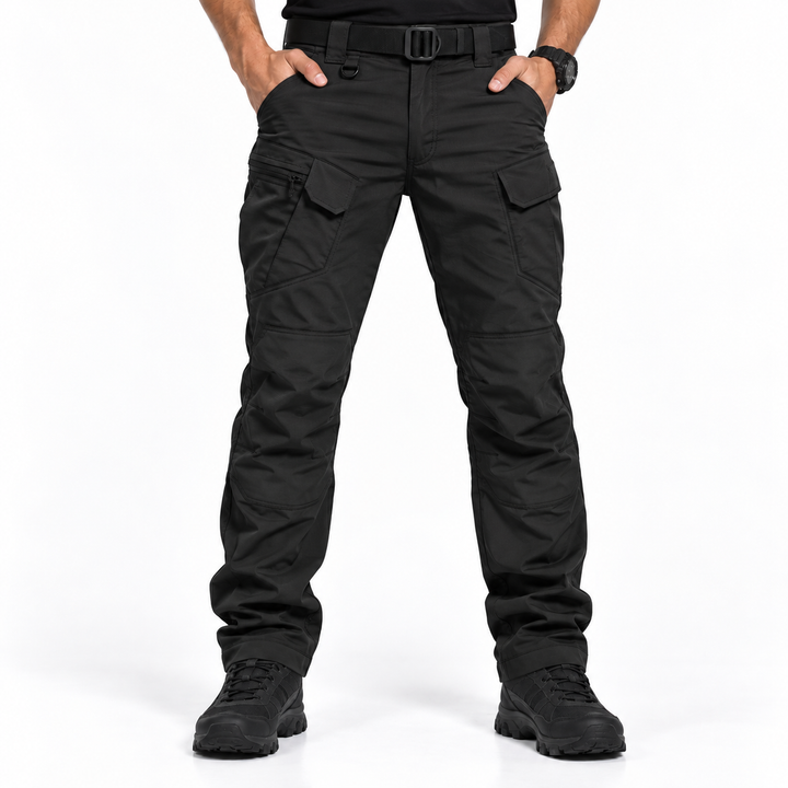 Man wearing black tactical cargo trousers standing against white background