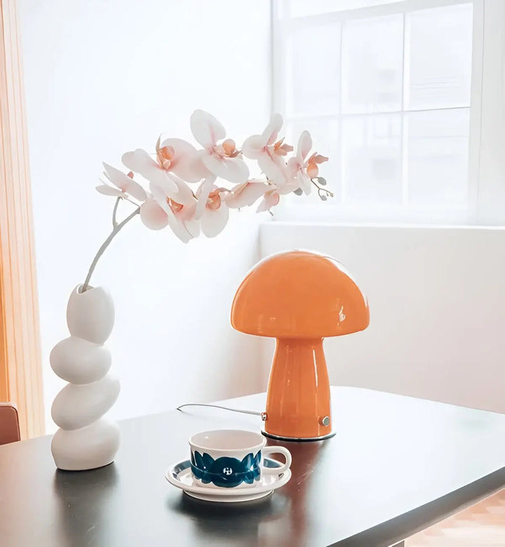 Minimalist orange bedside lamp showcasing its sleek curved glass silhouette