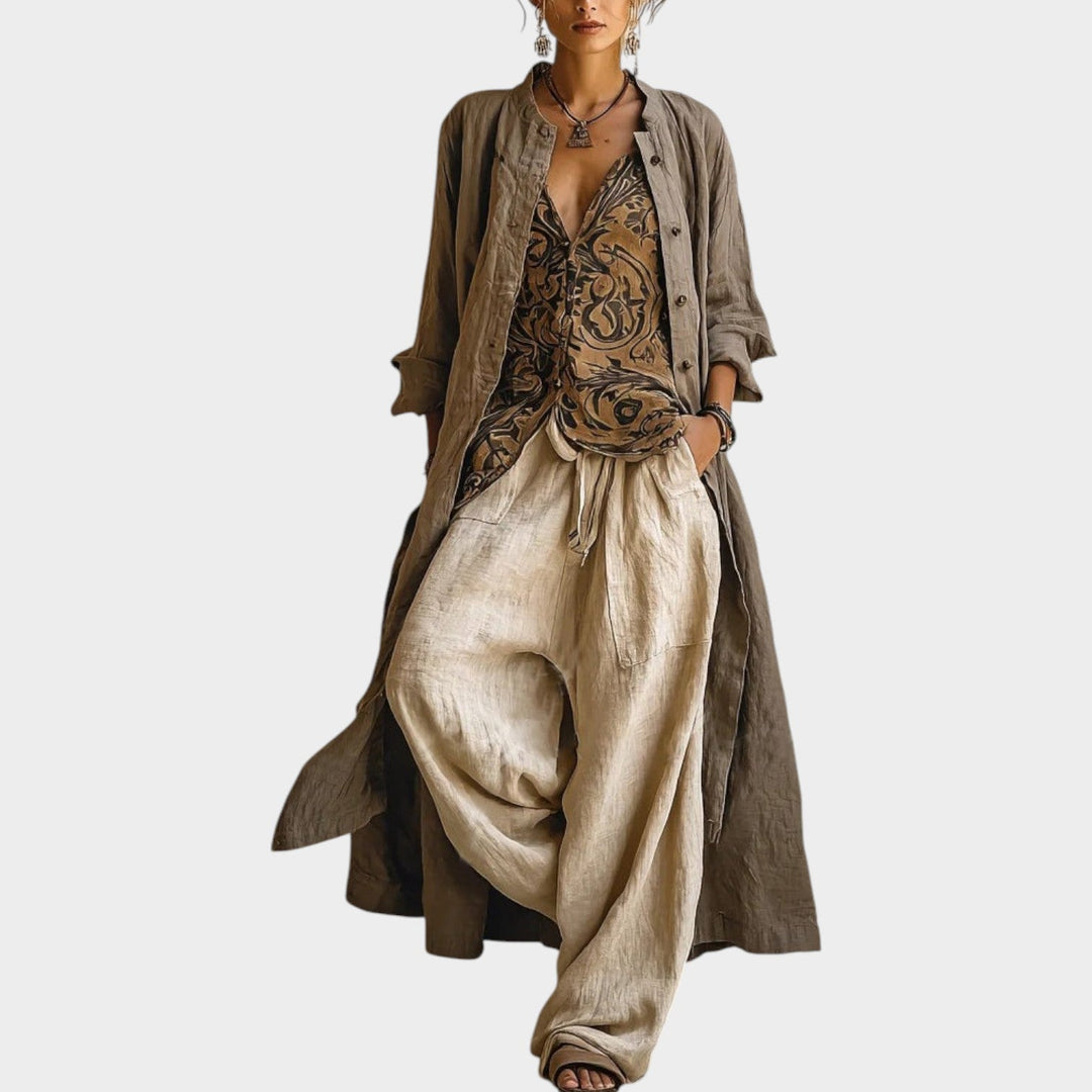 Front view of a woman wearing a beige three-piece longline jacket, printed top, and wide-leg trousers set.