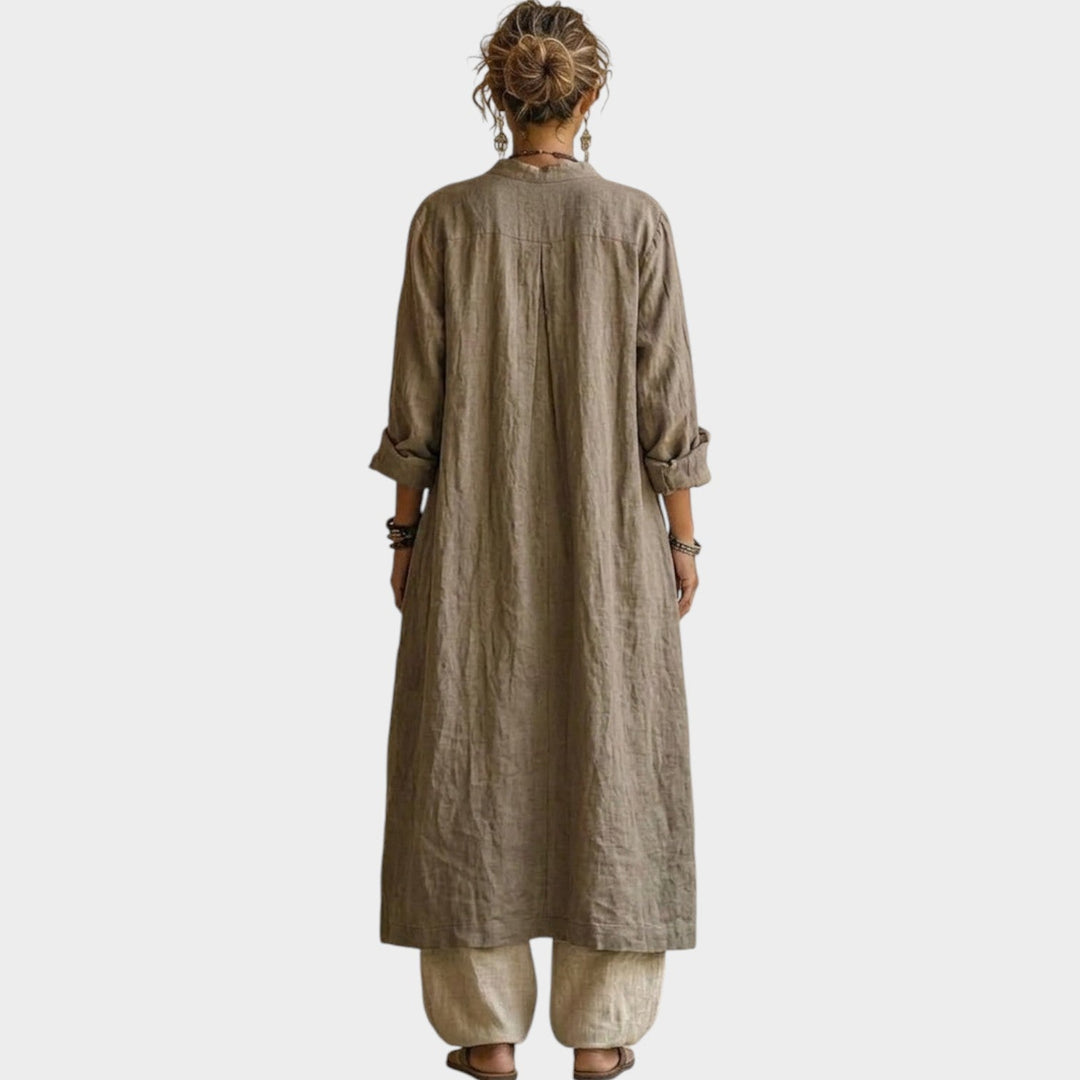 Back view of a woman wearing a beige longline jacket and relaxed trousers matching set.