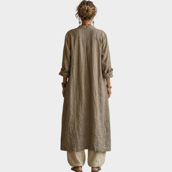 Back view of a woman wearing a beige longline jacket and relaxed trousers matching set.