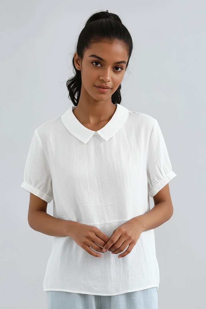 Close-up of model wearing white Peter Pan collar short sleeve blouse