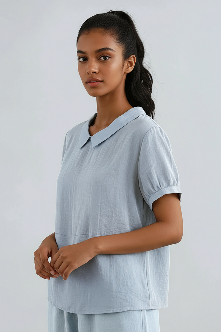 Side view of model in light blue Peter Pan collar short sleeve blouse
