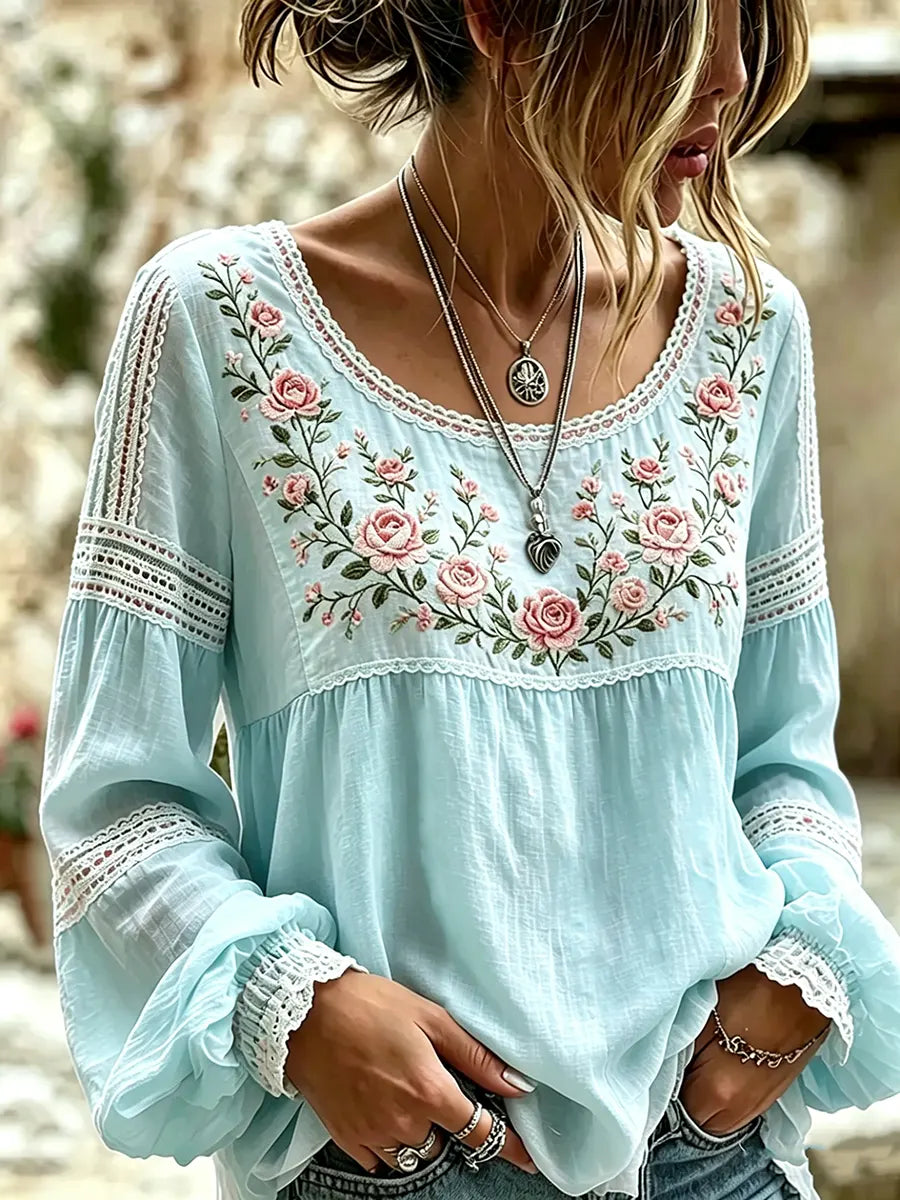 Lifestyle shot of a woman wearing the floral embroidered long-sleeve blouse outdoors