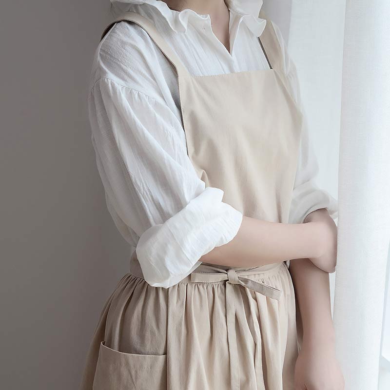 Baker wearing a beige waterproof apron while preparing dough at table