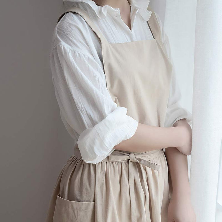 Baker wearing a beige waterproof apron while preparing dough at table