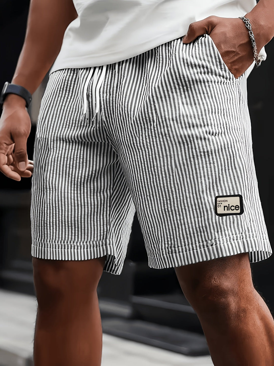 Close-up of a man wearing black and white striped casual shorts with drawstring