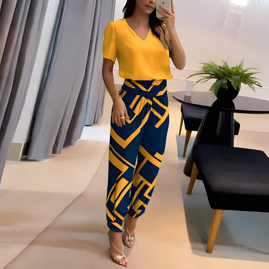 Woman wearing a yellow V-neck blouse and blue patterned pants two-piece set