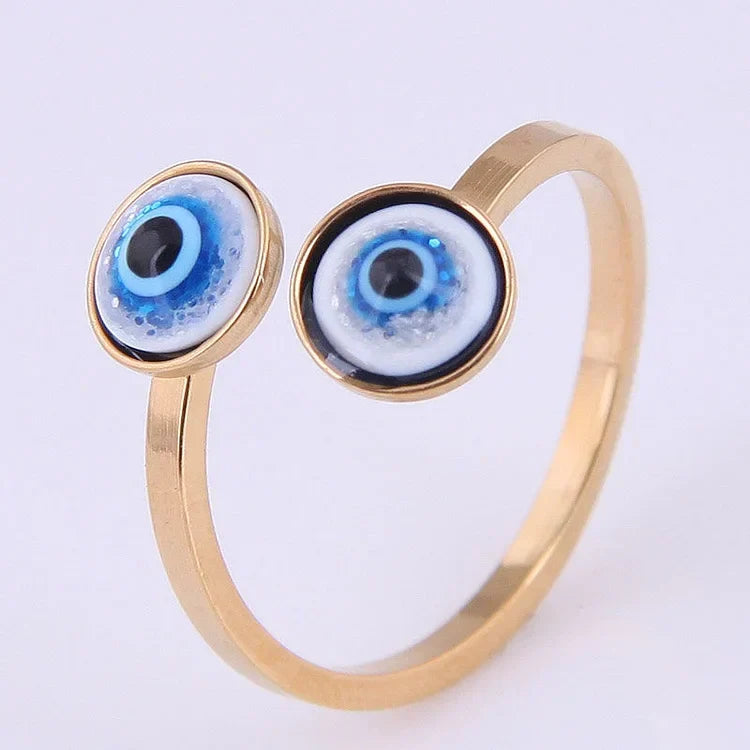Gold tone adjustable evil eye ring showcasing dual protective blue eye details in bright lighting