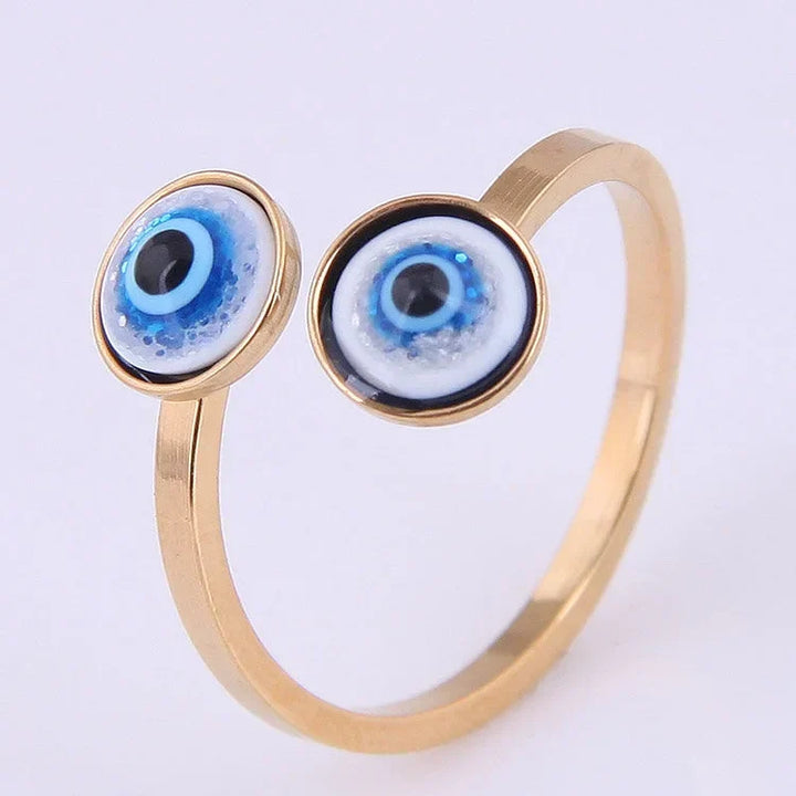 Gold tone adjustable evil eye ring showcasing dual protective blue eye details in bright lighting