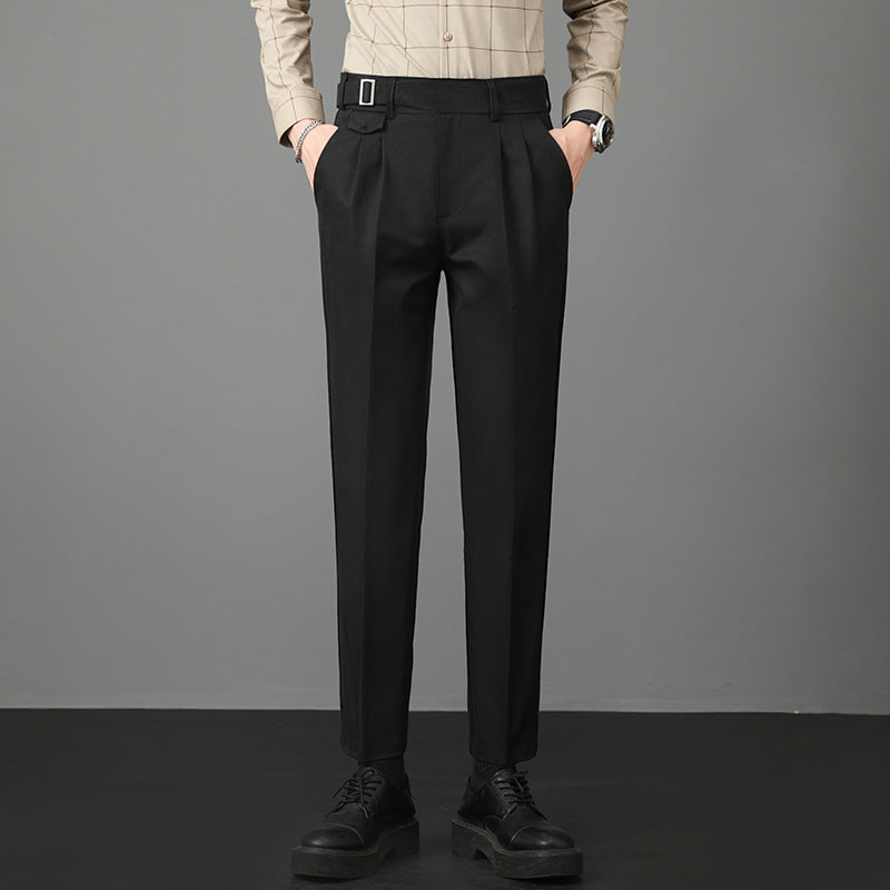 Man wearing black slim-fit straight-leg trousers with a buttoned shirt and black shoes.