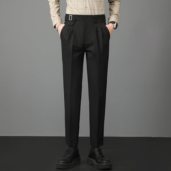 Man wearing black slim-fit straight-leg trousers with a buttoned shirt and black shoes.