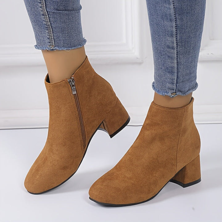 Woman wearing brown chelsea ankle boots with side zip