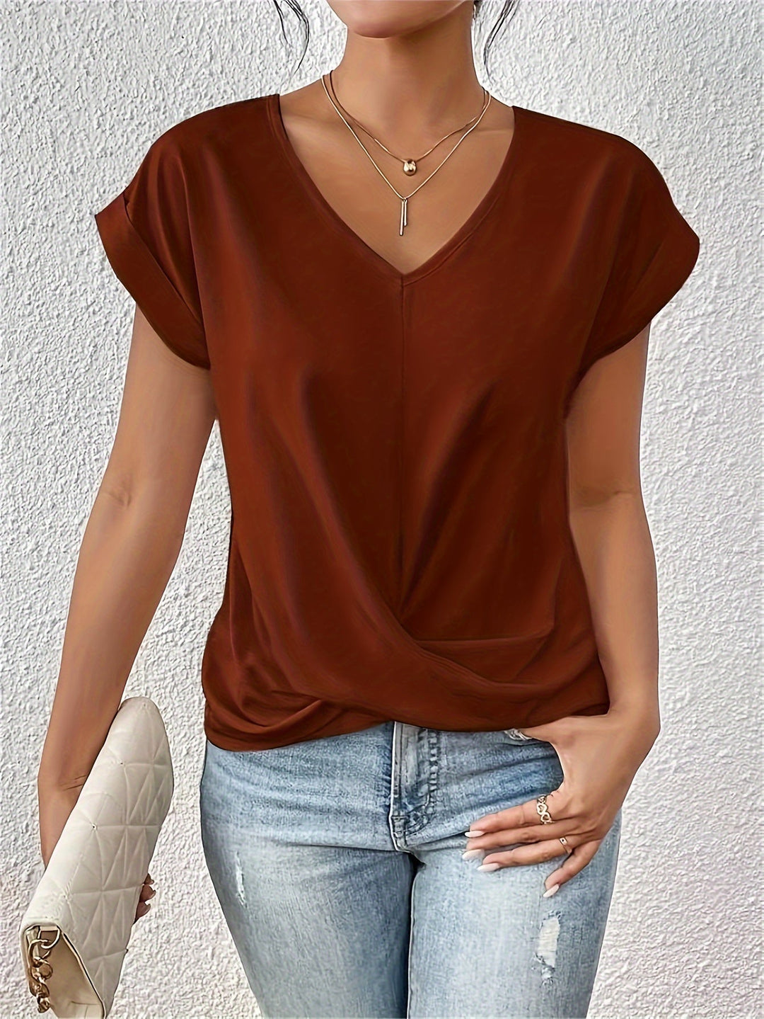 Woman wearing a brick red V-neck short-sleeve t-shirt with light wash jeans