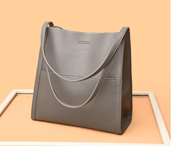 Green women's everyday bag worn over shoulder to demonstrate practical size