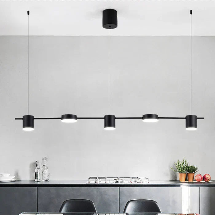 Sleek black aluminum pendant lamp installed above a modern kitchen island setup.