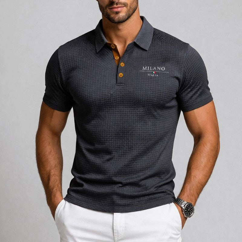 Man wearing dark grey textured polo shirt paired with white trousers