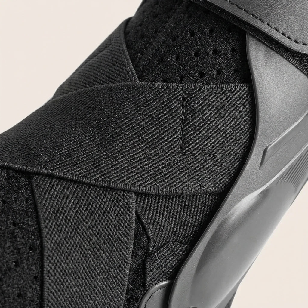Adjustable black and gray ankle support brace with stabilizing straps for sports and injury prevention athletic gear