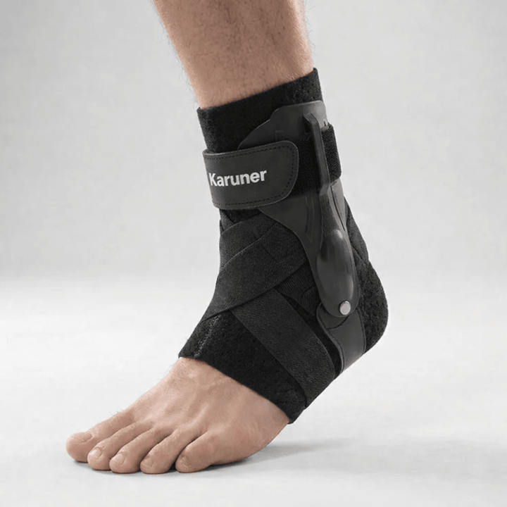 Close-up of a person wearing the black adjustable ankle support brace with side stabilizers