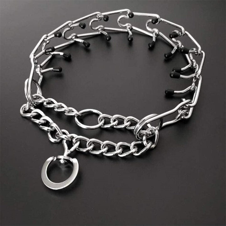Adjustable dog training collar with rubberized prongs displayed on a dark surface