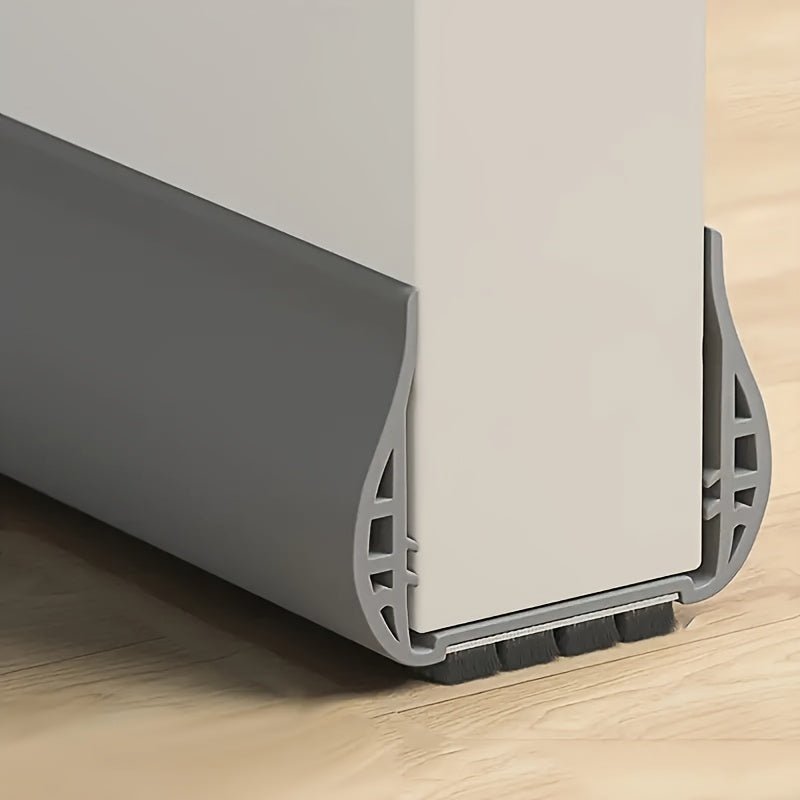 Gray adjustable door draft stopper installed on a white interior door