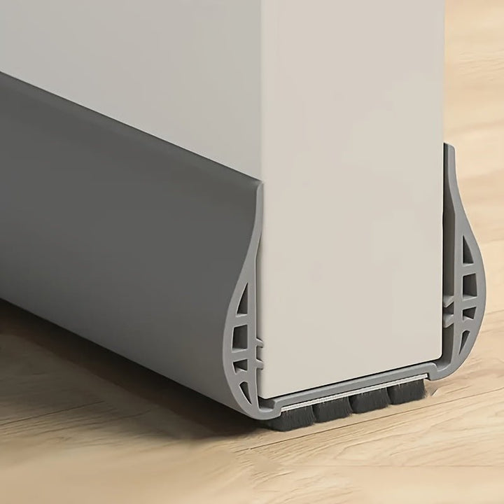 Gray adjustable door draft stopper installed on a white interior door