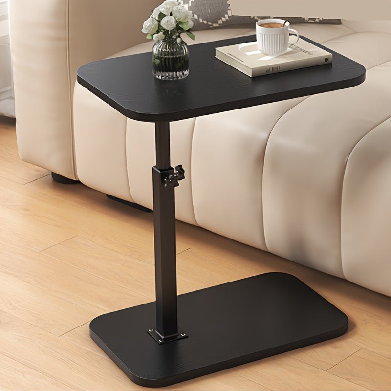 Adjustable black side table placed beside a modern beige sofa