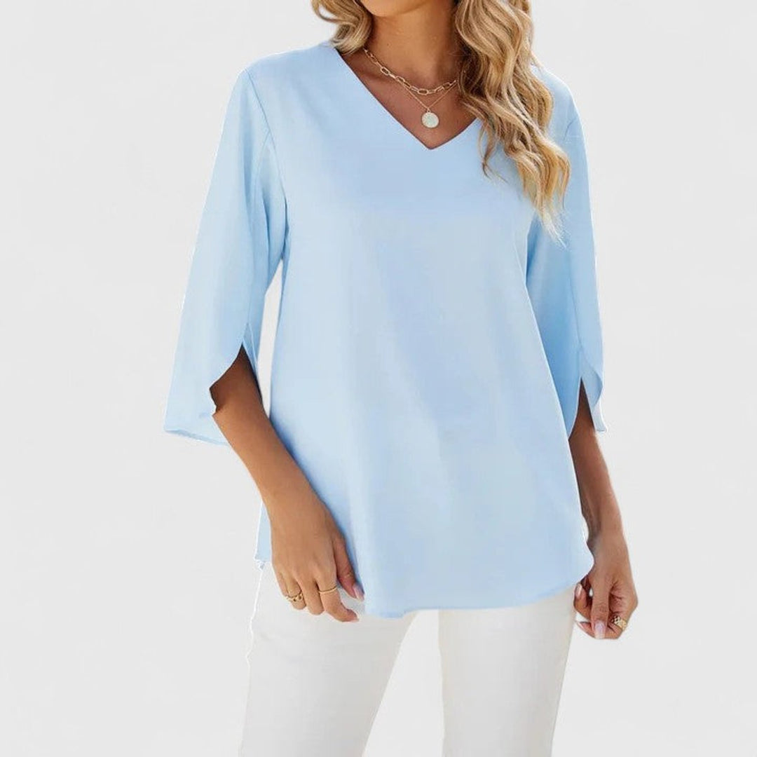 Close-up view of light blue ruffle front V-neck blouse with split 3/4 sleeves