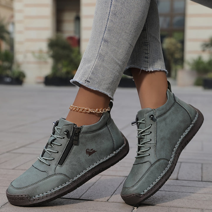 Sage green women's orthopaedic lace-up ankle sneakers worn outdoors with cropped jeans