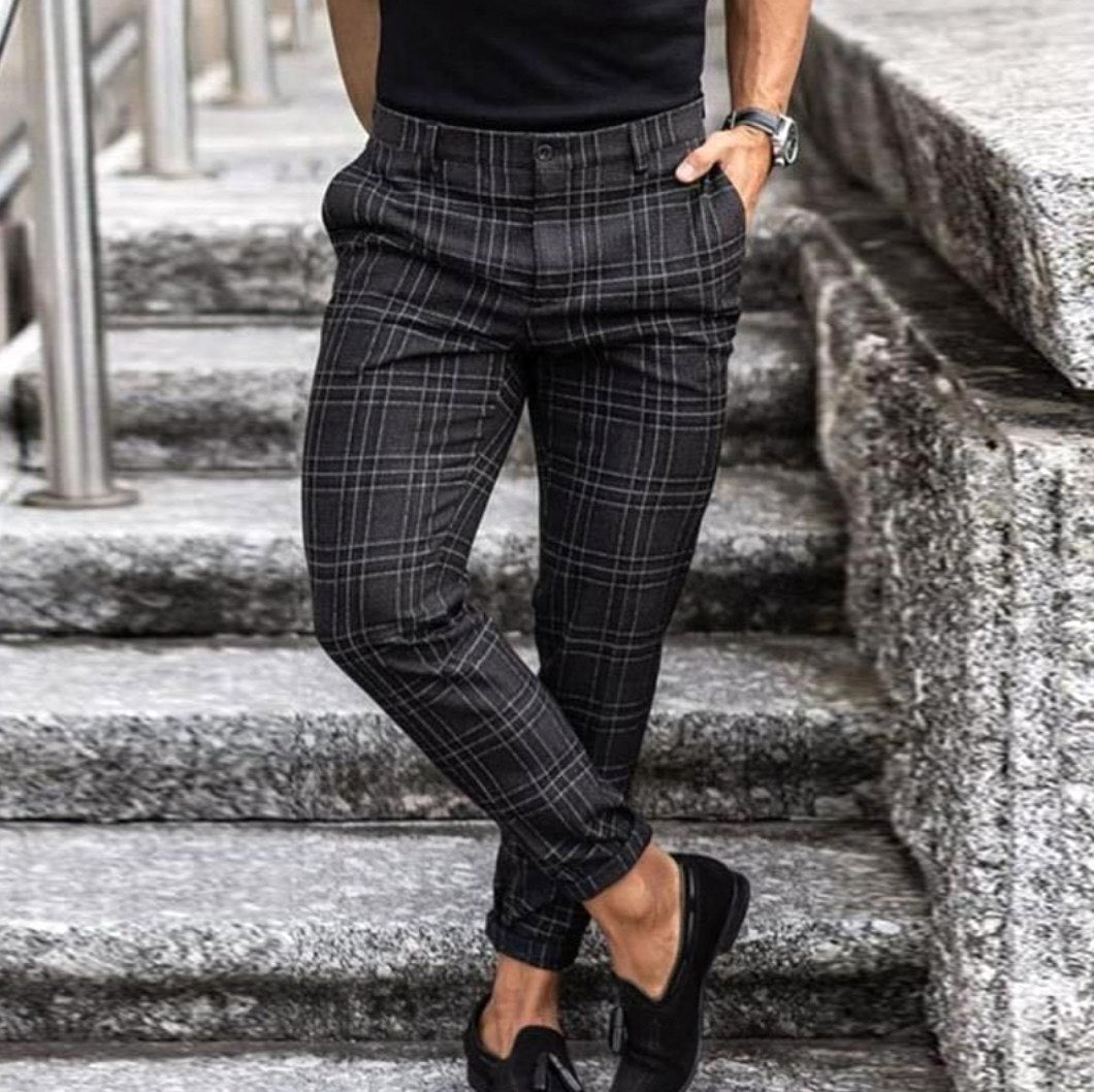 Man wearing dark check chinos with black shoes on stone steps