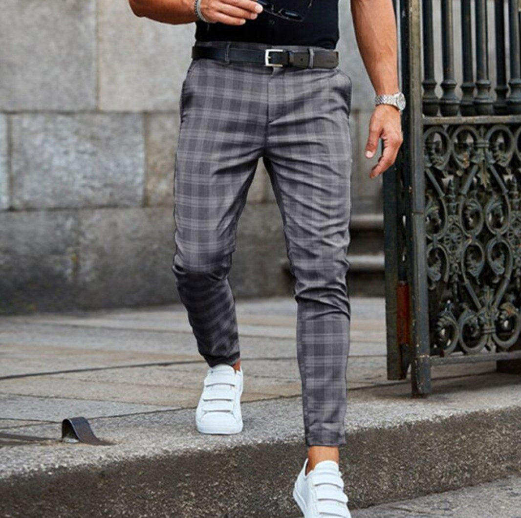 Man wearing gray check trousers with white sneakers outdoors